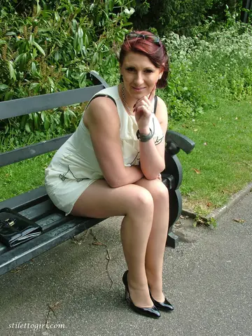 Redhead MILF Shows Off Stilettos and Curves on the Park Bench