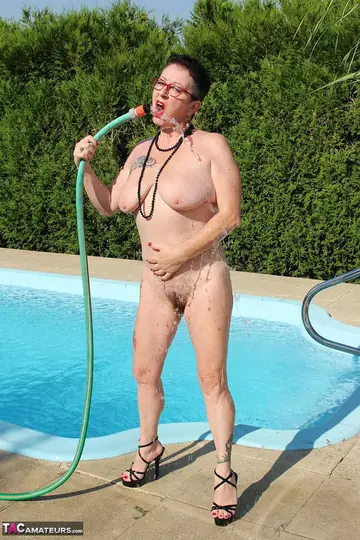 Mature Brunette Wets Her Hairy Bush with a Garden Hose Poolside