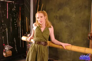 Nicki Blue – Pale Redhead in a Skirt Bound to a Bamboo Bar
