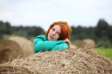 Thick Redhead Spreads Her Pussy on a Round Hay Bale