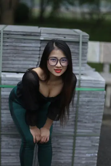 Asian Brunette with Big Tits Poses in a Top and Glasses Outdoors