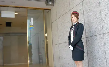 Japanese Redhead in Uniform and Stockings Poses in a Hotel