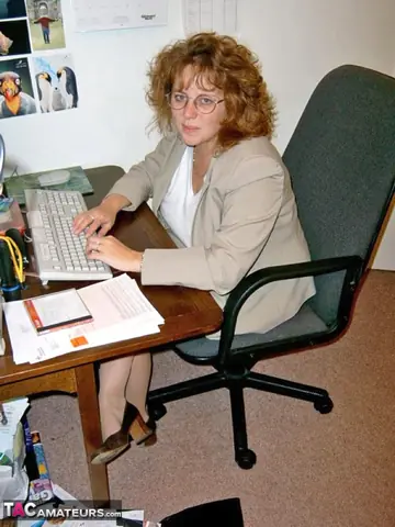 British Redhead MILF Poses in Lingerie and Boots at the Office