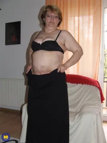 Mature European Woman Poses Naked in Glasses with a Cucumber