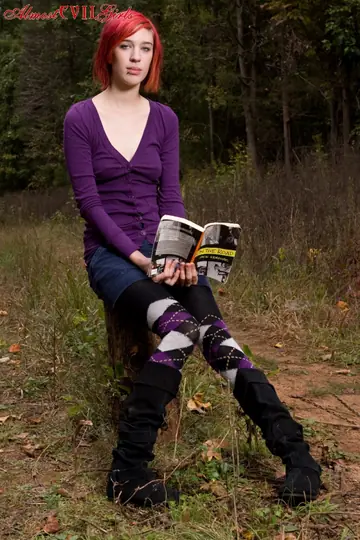 Redhead Pulls Pantyhose Aside to Show Her Pussy on a Stump