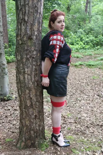 Thick Redhead in a Skirt and Leather Bound to a Tree