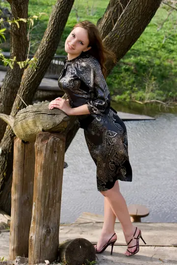 European Brunette in a Skirt and High Heels Spreads Outdoors