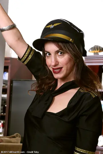 Sophya Love – Thick Mature Brunette Strips Out of Her Flight Attendant Uniform and Spreads