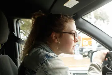 Amateur in Lingerie and Glasses Poses in a Car