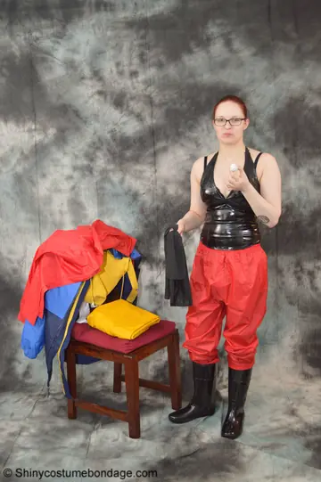 Pale Redhead in Latex Rain Suit and Boots Wears Glasses and a Cleave Gag