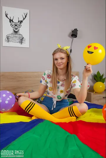 Slim Blonde Plays with a Balloon Before Stripping Nude on the Bed