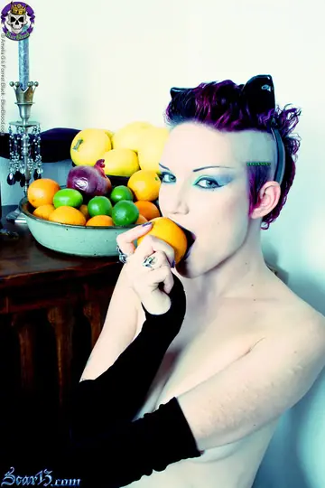 Scar 13 – Tattooed Short-Haired Brunette Bites Citrus Fruit Nude