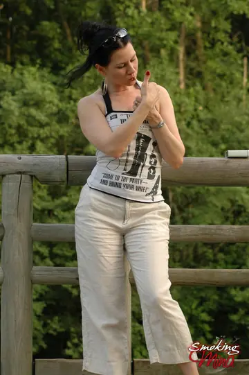 Brunette PAWG Poses Fully Clothed Outdoors by a Fence