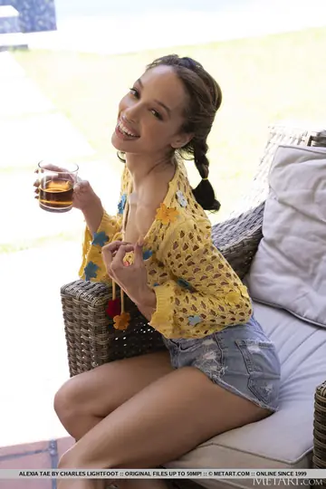 Alexis Tae – Ebony Brunette with Pigtails Strips and Poses on a Backyard Chair