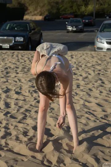 Penny Stiles – Petite Redhead in a Bikini and Glasses Spreads on the Beach