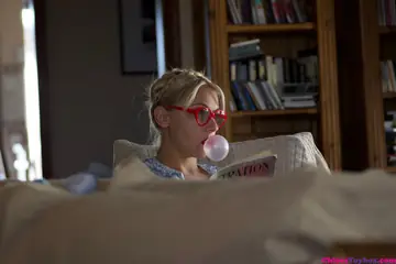 Skinny Blonde in a Skirt and Glasses Plays with a Toy