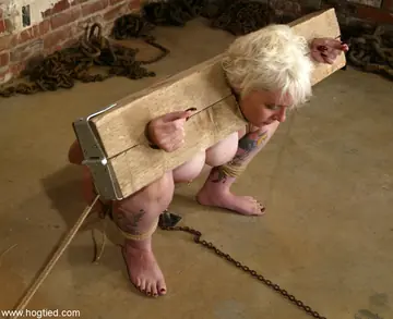 Busty Short-Haired Woman in Bondage Plays with a Dildo