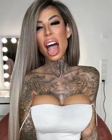 Busty Tattooed MILF Poses in Pink Fishnet Lingerie