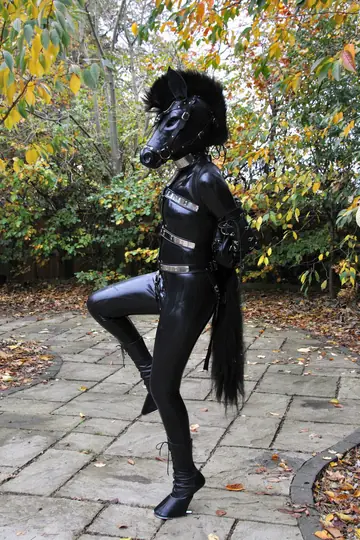 Woman in Latex Poses Outdoors in Bondage on a Horse