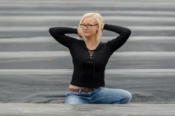 Short-Haired Blonde in Jeans and Glasses Poses Outdoors