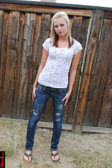 Blonde Amateur Poses in a White Shirt and Jeans Outdoors
