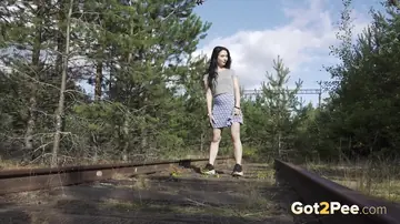Brunette Lifts Her Skirt and Pisses on Railway Tracks