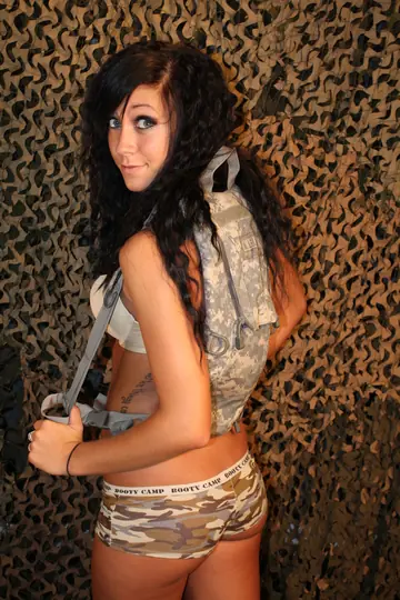 Brunette in Uniform Poses Nude with a Gun