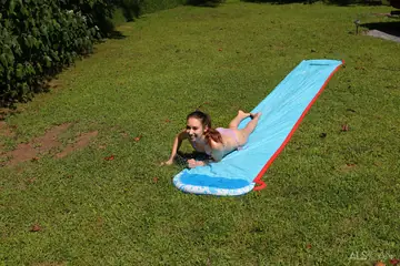 Nicole Auclair – Brunette in a Bikini and Panties Spreads on a Garden Slide