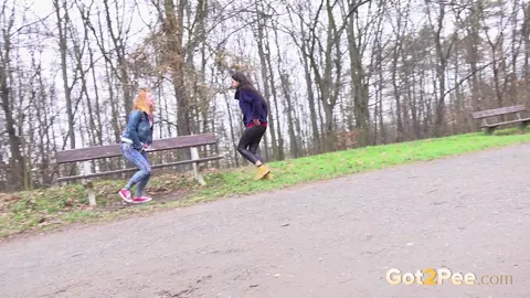 Chrissy Fox: Brunette and Redhead Squat to Pee in Jeans Near Park Bench – photo 2 of 15