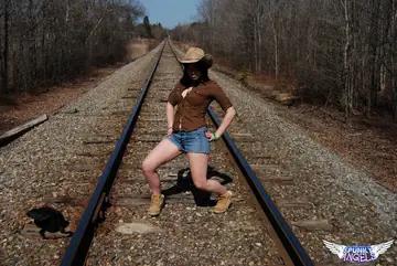Emily Love – Amateur Brunette in Shorts and Boots Spreads on Railway Tracks