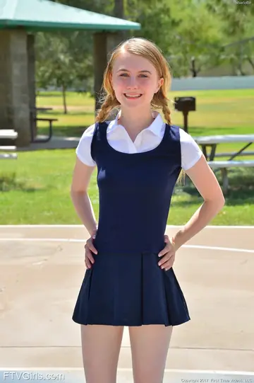 Skinny Blonde in Uniform Skirt Spreads Outdoors