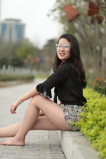 Petite Asian in a Skirt and Shorts Poses Barefoot Outdoors