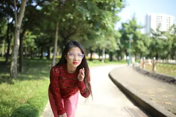 Asian Brunette in Yoga Pants and Glasses Poses Outdoors