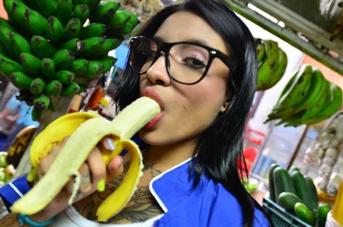 Marly Romero: Tattooed Latina in Glasses Eats a Banana Outdoors – photo 7 of 15