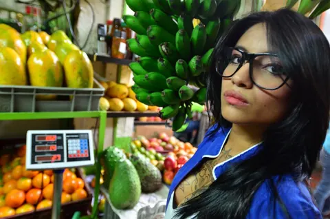 Marly Romero: Tattooed Latina in Glasses Eats a Banana Outdoors – photo 14 of 15
