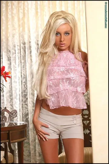 Blonde with Big Enhanced Tits Poses in Shorts