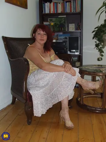 Mature Redhead Undresses and Fingers Her Pussy in a Chair