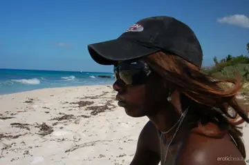 Ebony Babe in Glasses and Bikini Bares Her Shaved Pussy on the Beach